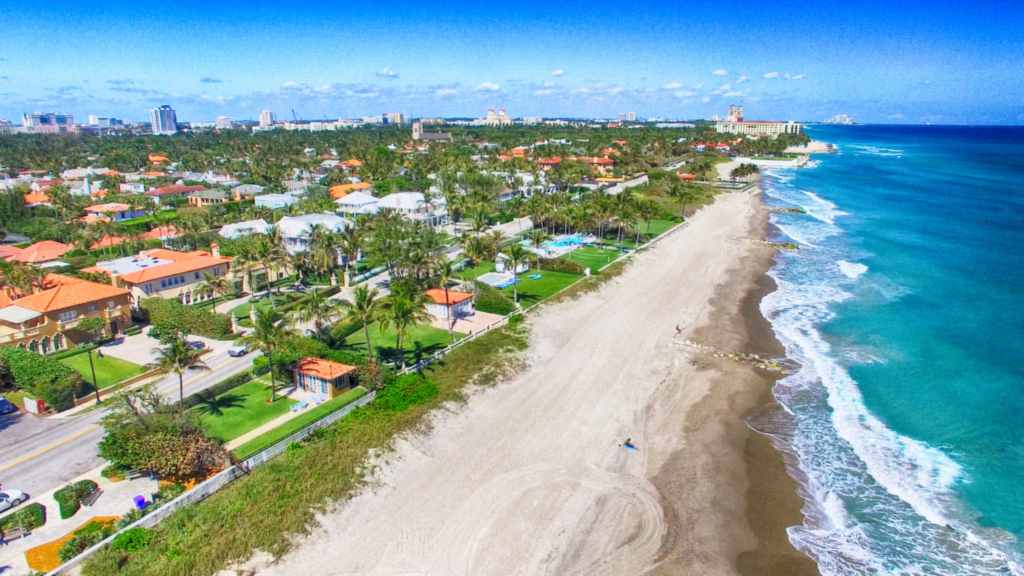 Aerial view of the Palm Beach coastline — palm trees, homes and turquoise water